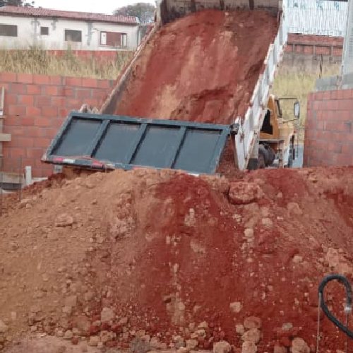 Caminhão basculante descarregando terra em obra da Empreiteira JSFZ
